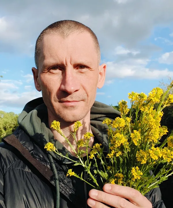 Mario, founder of LymeTutor, holding wild flowers he foraged